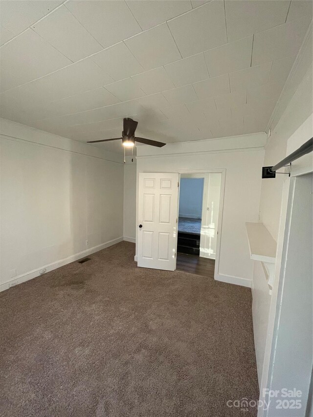 spare room with dark carpet and ceiling fan