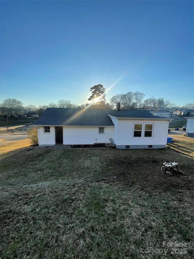 rear view of house featuring a yard