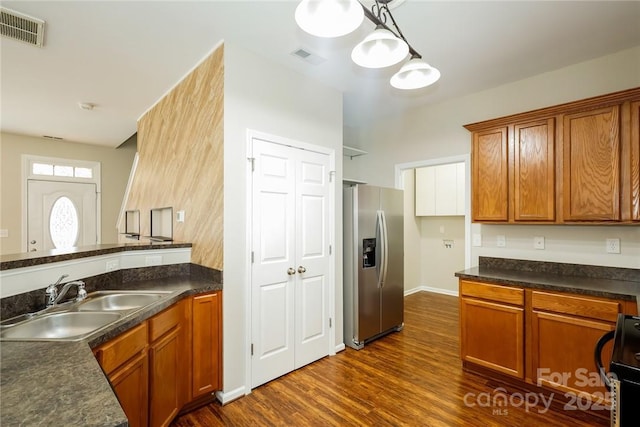 kitchen featuring sink, decorative light fixtures, stainless steel fridge with ice dispenser, dark hardwood / wood-style flooring, and stove