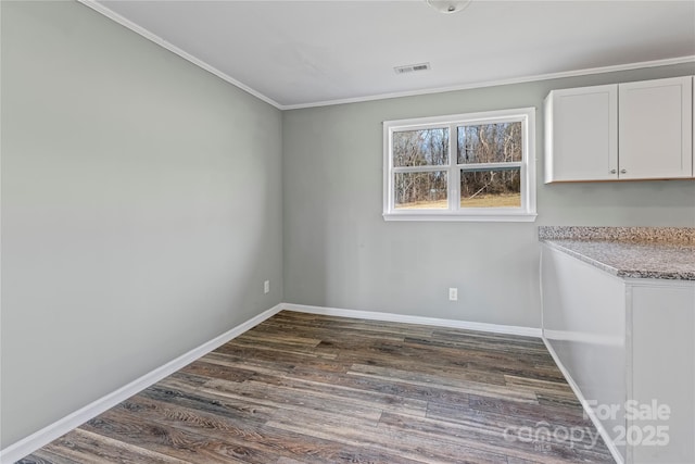 unfurnished dining area with ornamental molding and dark hardwood / wood-style floors