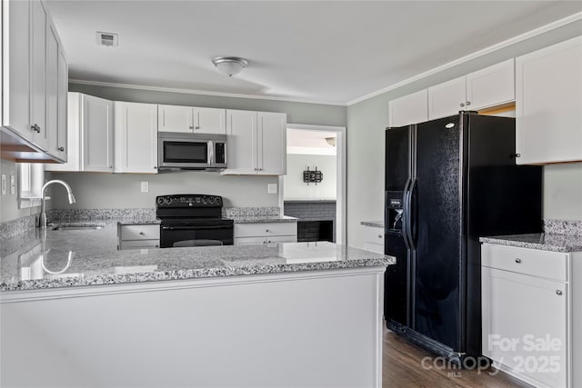 kitchen featuring sink, ornamental molding, black appliances, white cabinets, and kitchen peninsula