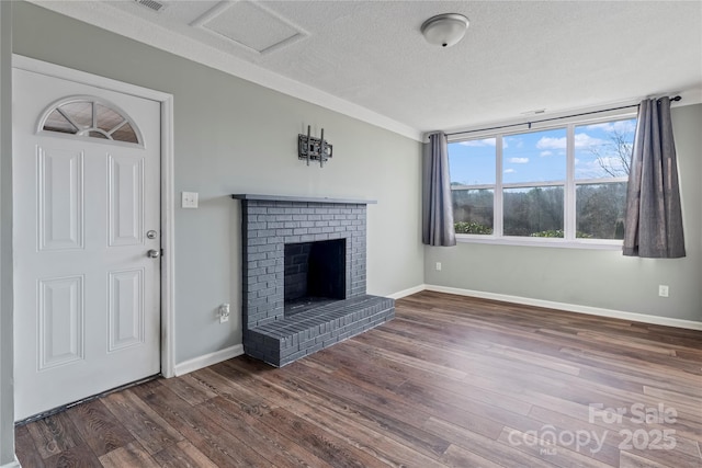 unfurnished living room with dark wood-type flooring, a fireplace, and a textured ceiling