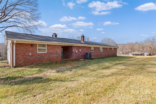 rear view of house featuring a yard and central AC