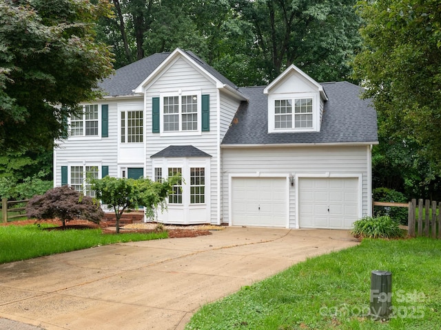 172 Foxtail Dr, Mooresville, NC 28117 - traditional-style home with driveway, roof with shingles, an attached garage, and view of wooded area