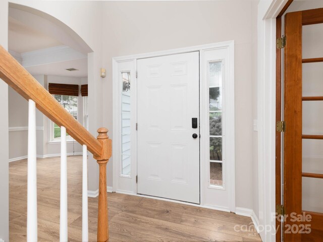 172 Foxtail Dr, Mooresville, NC 28117 - foyer entrance featuring wood finished floors, stairs, arched walkways, and baseboards