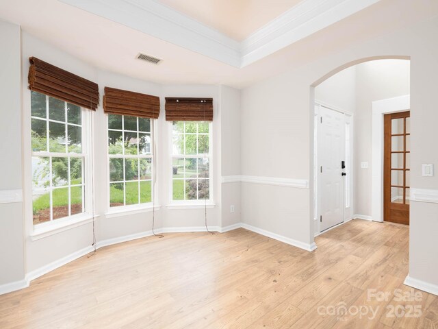 172 Foxtail Dr, Mooresville, NC 28117 - spare room featuring arched walkways, light wood-style floors, ornamental molding, and baseboards