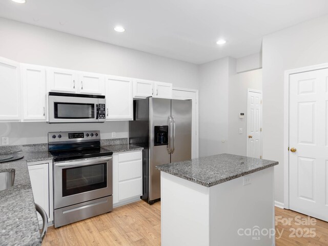 172 Foxtail Dr, Mooresville, NC 28117 - kitchen with appliances with stainless steel finishes, white cabinets, light wood finished floors, a center island, and recessed lighting