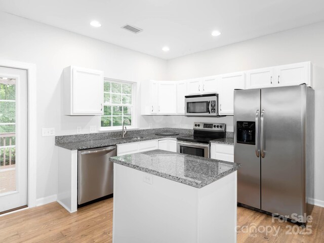 172 Foxtail Dr, Mooresville, NC 28117 - kitchen with stainless steel appliances, a sink, dark stone counters, white cabinets, and recessed lighting