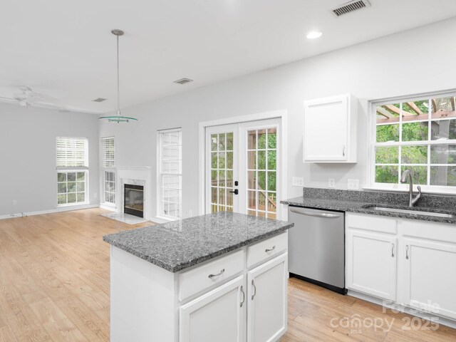 172 Foxtail Dr, Mooresville, NC 28117 - kitchen featuring dishwasher, a sink, french doors, light wood-style flooring, and dark stone counters