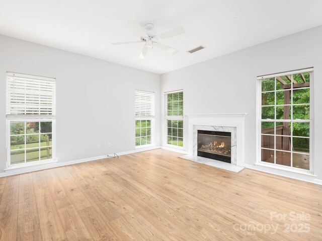 172 Foxtail Dr, Mooresville, NC 28117 - unfurnished living room with a high end fireplace, light wood-type flooring, a ceiling fan, and baseboards