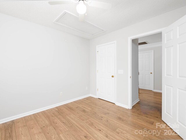 172 Foxtail Dr, Mooresville, NC 28117 - unfurnished bedroom featuring light wood-type flooring, baseboards, attic access, and a ceiling fan