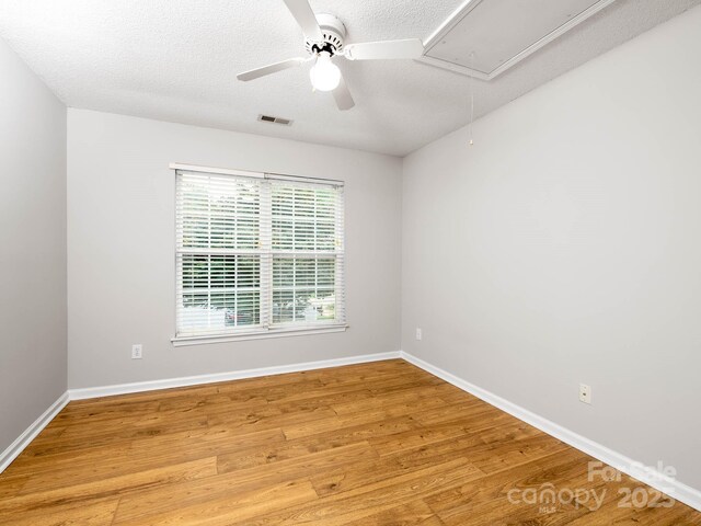 172 Foxtail Dr, Mooresville, NC 28117 - empty room with attic access, a ceiling fan, wood finished floors, a textured ceiling, and baseboards