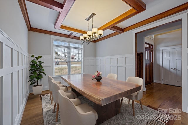 dining space featuring coffered ceiling, dark hardwood / wood-style floors, a chandelier, and beam ceiling