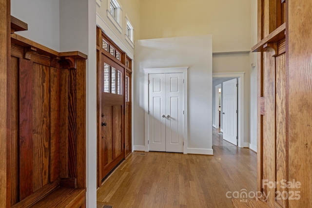 foyer entrance with light wood-type flooring and a high ceiling