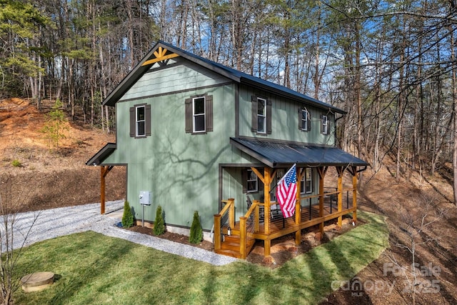 view of front of house with a porch, metal roof, and a front lawn