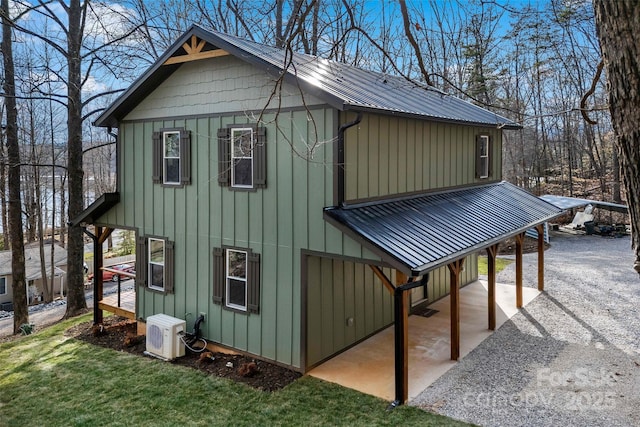 view of property exterior featuring ac unit, metal roof, and board and batten siding