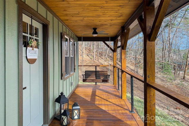 wooden terrace with covered porch and a ceiling fan