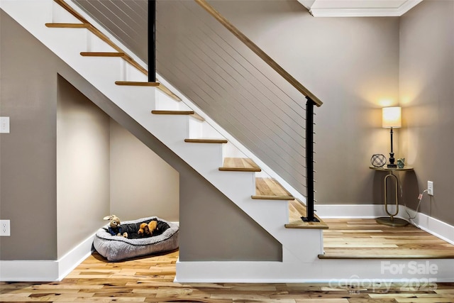 stairway featuring baseboards and wood finished floors