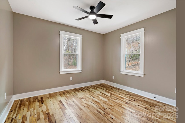 spare room featuring light wood-style floors, baseboards, and ceiling fan