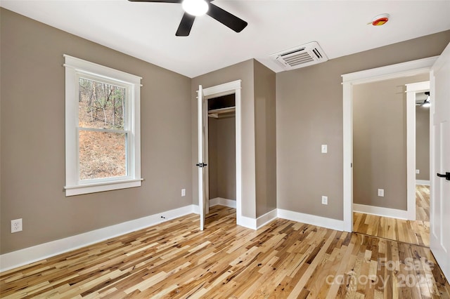 unfurnished bedroom with light wood finished floors, visible vents, a closet, and baseboards