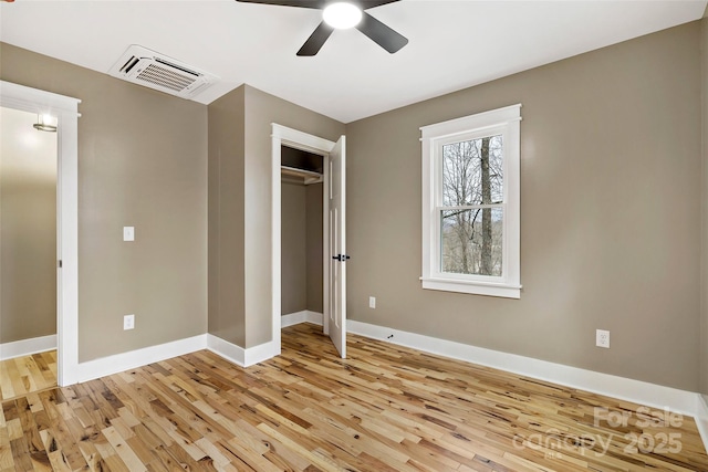 unfurnished bedroom featuring light wood-type flooring, visible vents, a ceiling fan, a closet, and baseboards