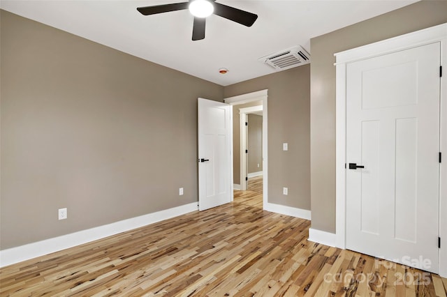 unfurnished bedroom with visible vents, light wood-style flooring, a ceiling fan, and baseboards