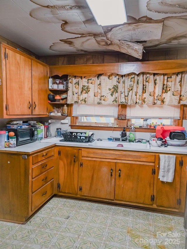 316 E 4th Ave, Gastonia, NC 28054 - kitchen featuring light countertops, light floors, and brown cabinets