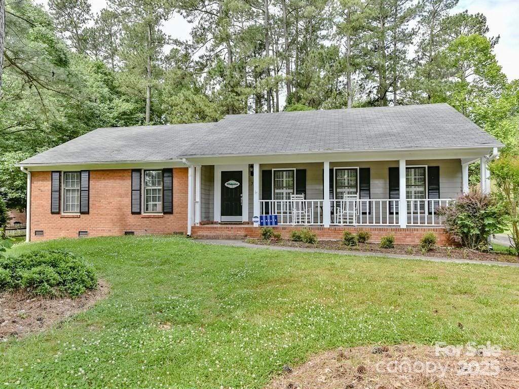 single story home with a front yard and covered porch