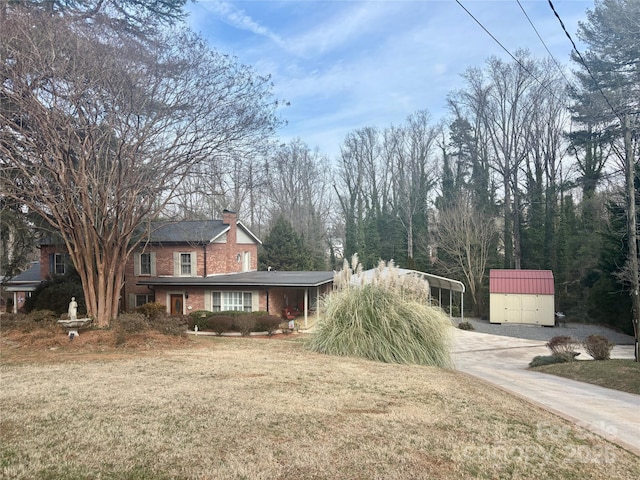 exterior space with a carport, a storage shed, and a front yard