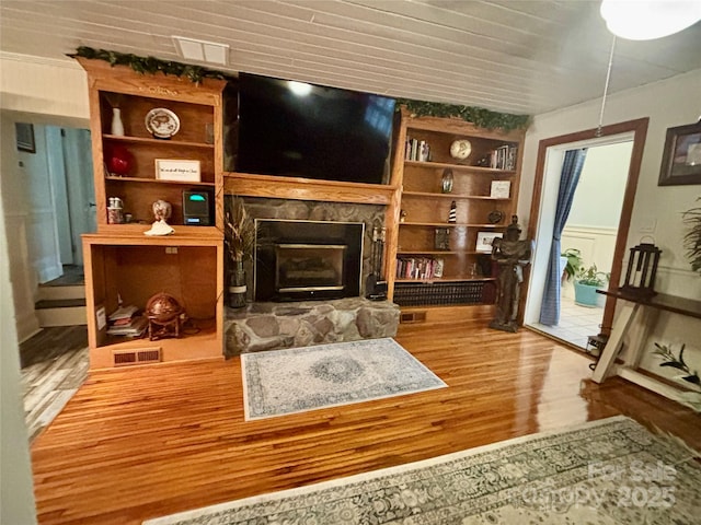 sitting room with wood-type flooring and a stone fireplace