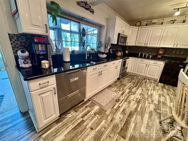 kitchen featuring stainless steel appliances, white cabinetry, sink, and light hardwood / wood-style flooring