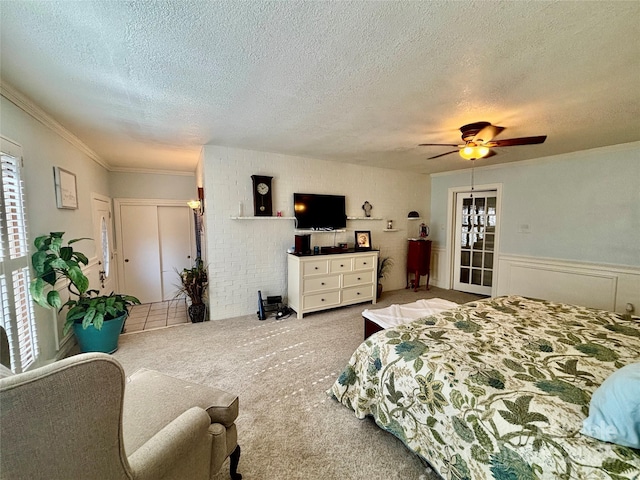 carpeted bedroom featuring crown molding, a textured ceiling, and ceiling fan