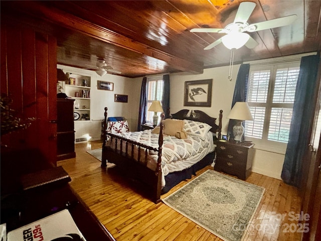 bedroom with wood ceiling, hardwood / wood-style floors, and multiple windows