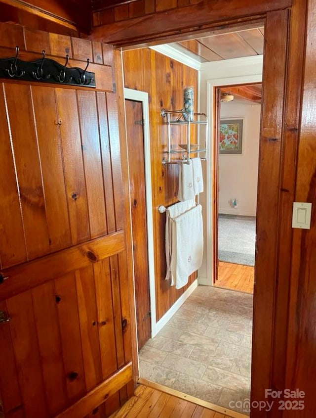 hall featuring light hardwood / wood-style flooring and wood walls