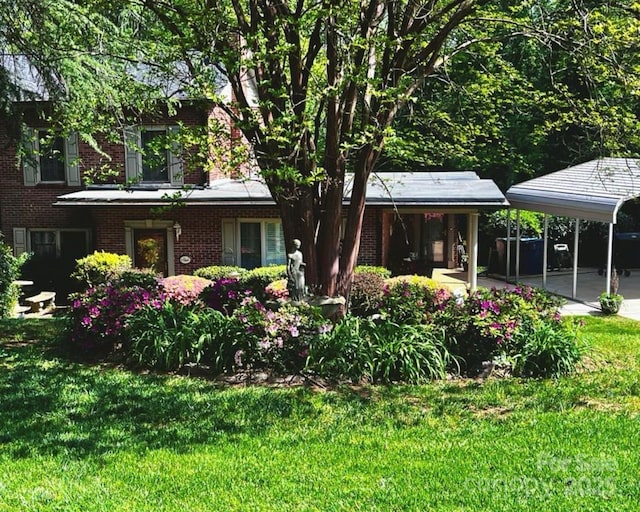 rear view of house featuring a lawn and a carport