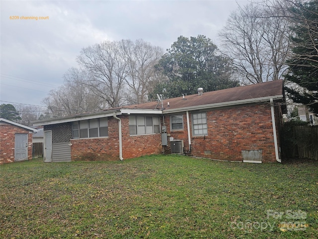 back of property with a yard and central air condition unit