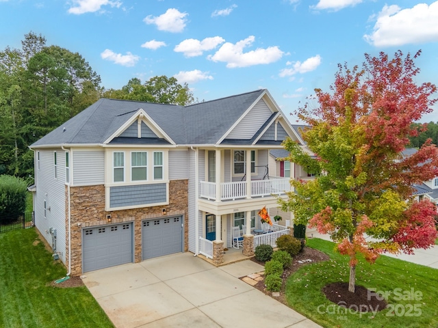 view of front of home with a garage, a front lawn, a balcony, and a porch