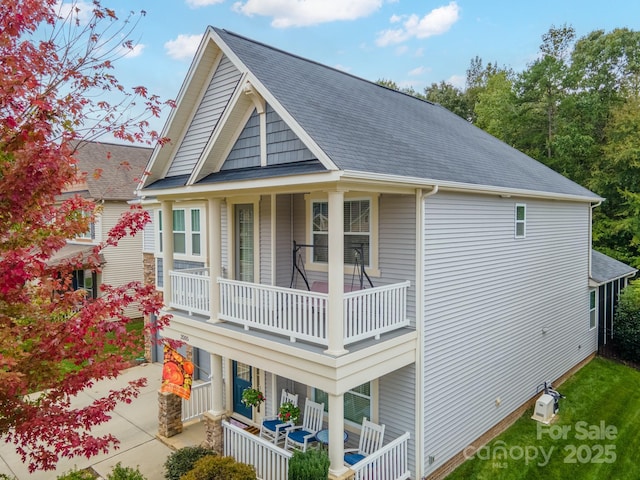 rear view of property with a balcony and a porch