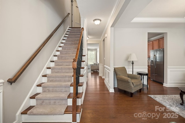 staircase with crown molding and hardwood / wood-style floors