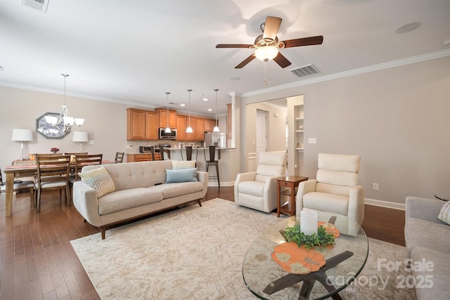 living room with crown molding, ceiling fan with notable chandelier, and hardwood / wood-style floors