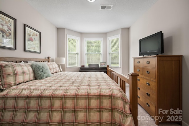 carpeted bedroom featuring a textured ceiling