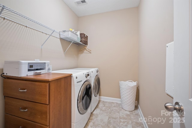 clothes washing area with washing machine and dryer and light tile patterned flooring