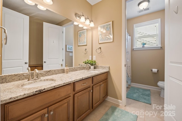 bathroom with vanity, tile patterned floors, toilet, and walk in shower