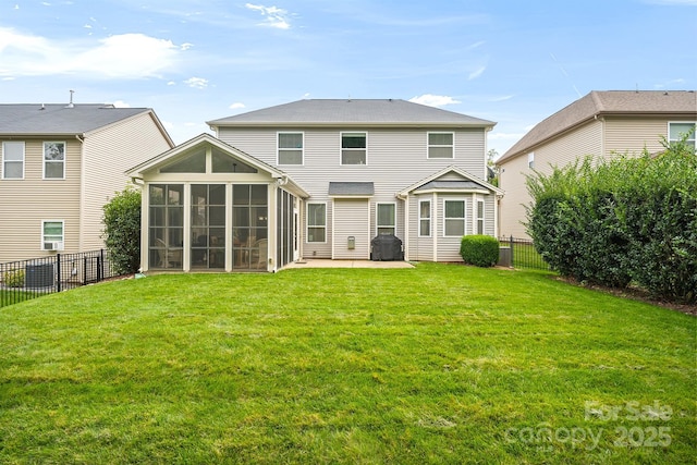 back of house featuring a lawn, a sunroom, and a patio