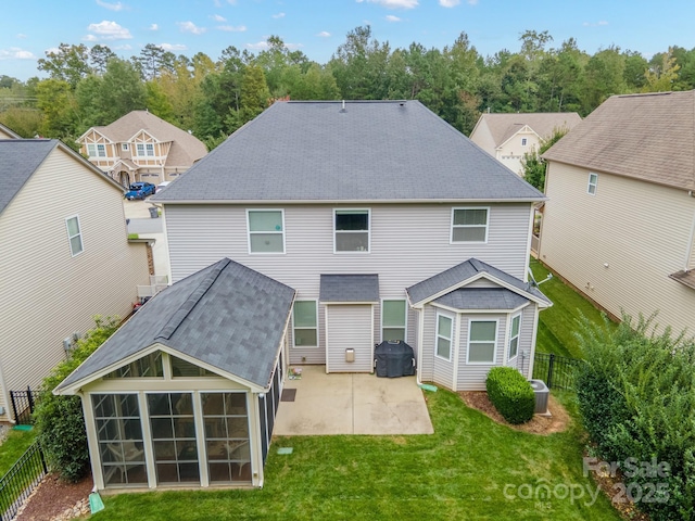 rear view of house featuring cooling unit, a lawn, a sunroom, and a patio