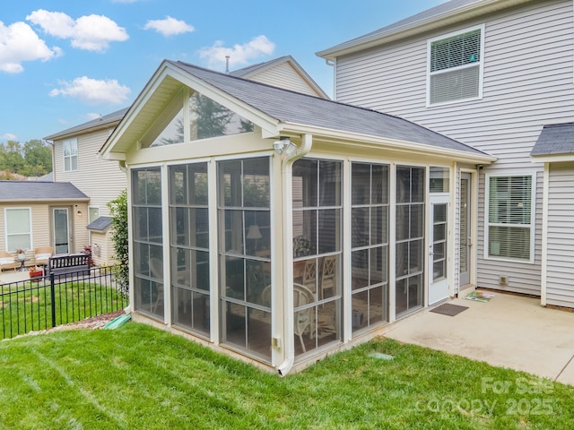 rear view of house with a patio, a yard, and a sunroom