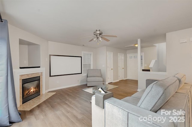 cinema featuring a fireplace, light hardwood / wood-style flooring, and ceiling fan