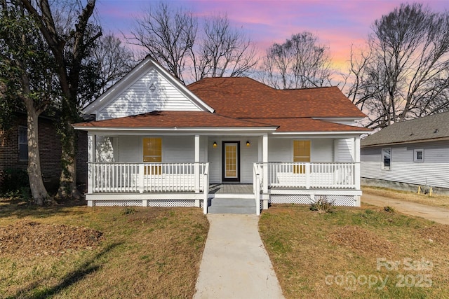 farmhouse inspired home featuring a lawn and a porch