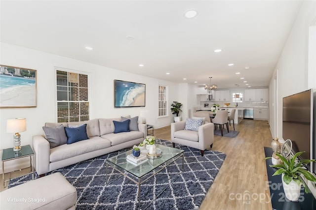 living room with a chandelier and light wood-type flooring