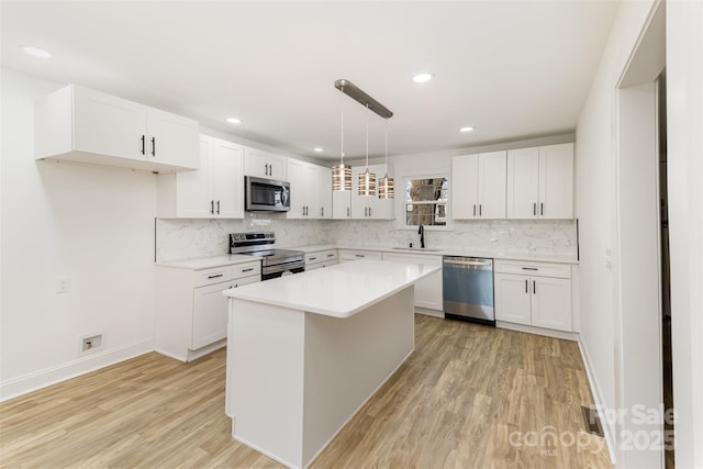 kitchen featuring appliances with stainless steel finishes, white cabinetry, and a center island